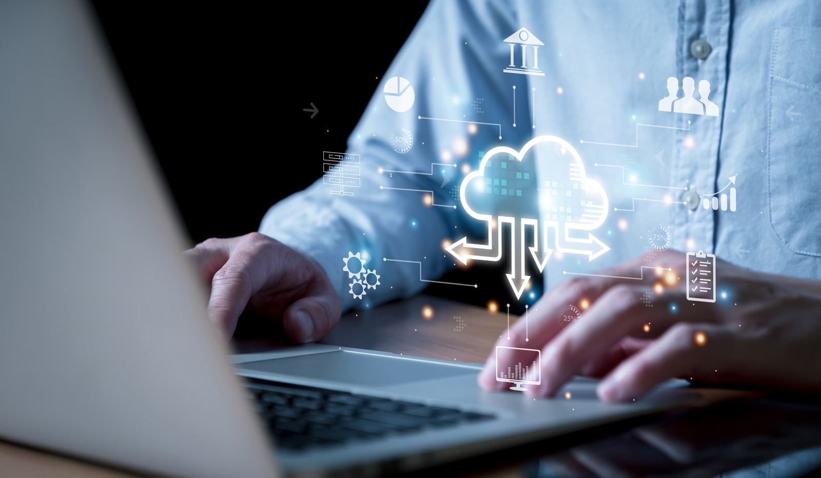 A person types on a laptop with cloud computing graphics, including a cloud symbol, arrows, and digital icons, overlaid in the foreground, representing data storage, disaster recovery planning, and technology concepts.